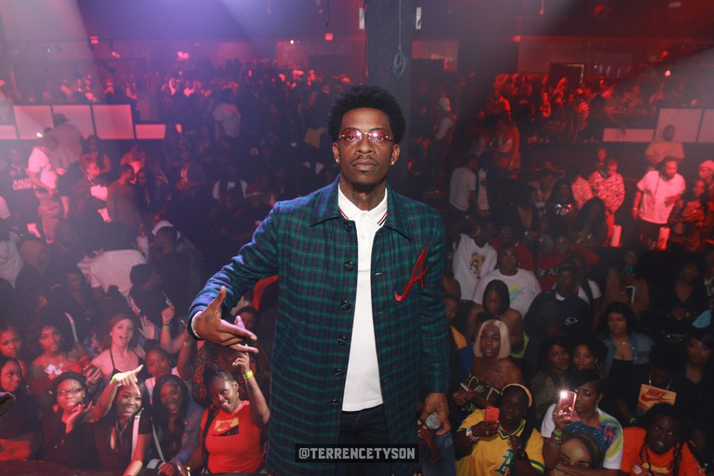 Rich Homie Quan standing on stage with audience crowd behind him
